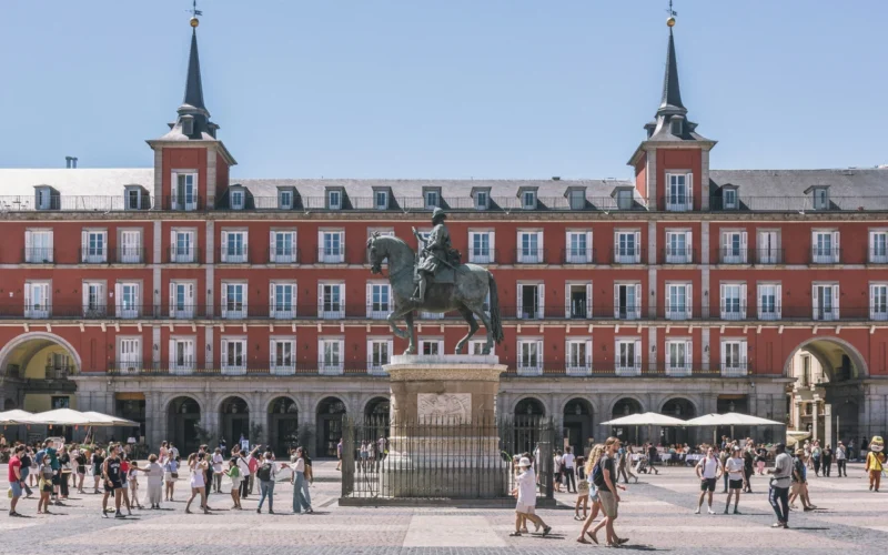 Panorama Plaza Mayor w Madrycie z charakterystycznymi czerwonymi budynkami i pomnikiem na środku